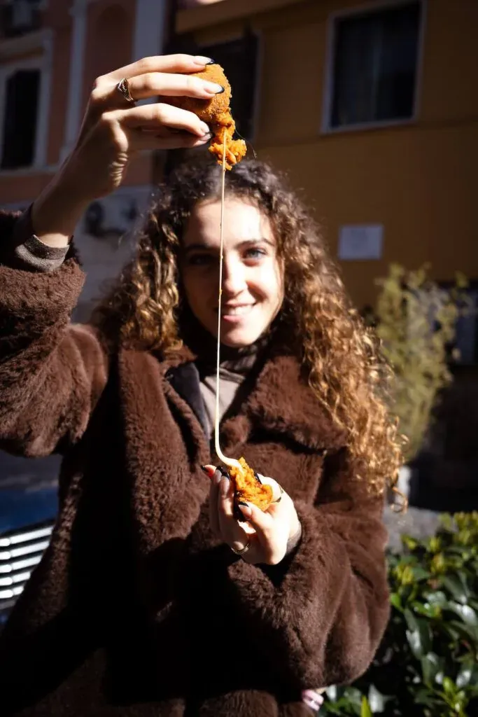 Woman enjoying a slice of pizza during a Carpe Diem food tour in Rome, Italy